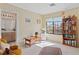 Bedroom featuring bright windows, a bookshelf, a view of the bathroom, and a comfortable arm chair at 8432 Squaw Valley Ave, Las Vegas, NV 89128