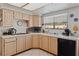 Bright kitchen features tiled countertops, light wood cabinets, and a window overlooking the backyard at 8432 Squaw Valley Ave, Las Vegas, NV 89128