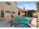 Backyard pool featuring a jacuzzi, potted plants, and tall, well-manicured hedges at 8432 Squaw Valley Ave, Las Vegas, NV 89128