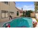 Backyard pool featuring a jacuzzi, potted plants, and tall, well-manicured hedges at 8432 Squaw Valley Ave, Las Vegas, NV 89128