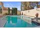 The pool features a hot tub, ladder, and tall privacy hedges on the property line at 8432 Squaw Valley Ave, Las Vegas, NV 89128