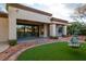 Backyard showcasing a covered patio, green lawn, and desert landscaping at 10534 Mandarino Ave, Las Vegas, NV 89135