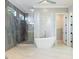 A luxurious bathroom with a standalone tub and a glass-enclosed shower with stone-look walls at 10534 Mandarino Ave, Las Vegas, NV 89135