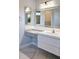 A modern bathroom vanity with double sinks, white countertops, and soft gray cabinets at 10534 Mandarino Ave, Las Vegas, NV 89135