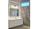A modern bathroom vanity with a sleek white countertop and a framed mirror at 10534 Mandarino Ave, Las Vegas, NV 89135