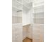 A walk-in closet with white built-in shelving and drawers at 10534 Mandarino Ave, Las Vegas, NV 89135