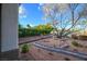 Beautifully landscaped front yard with decorative rock, mature tree and brick-lined garden bed at 10534 Mandarino Ave, Las Vegas, NV 89135