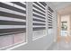 Three large windows with black and gray shades that provide natural light at 10534 Mandarino Ave, Las Vegas, NV 89135
