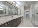 Modern bathroom featuring double vanity, framed mirrors, and a glass enclosed shower at 1056 Via Panfilo Ave, Henderson, NV 89011