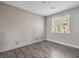 Bright bedroom with wood-look flooring, large windows, and accent wall paneling at 1056 Via Panfilo Ave, Henderson, NV 89011
