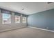 Large, brightly lit bedroom with three windows and light blue accent wall at 1056 Via Panfilo Ave, Henderson, NV 89011