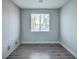 Empty room with modern paneling, wood-look flooring, and large windows with window blinds at 1056 Via Panfilo Ave, Henderson, NV 89011
