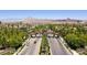 Striking aerial view of the community entrance, adorned with palm trees and manicured landscaping at 1056 Via Panfilo Ave, Henderson, NV 89011