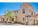 Beautiful two-story home with desert landscaping, arched windows, and a view of mature trees at 1056 Via Panfilo Ave, Henderson, NV 89011