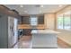 Well-lit kitchen with stainless steel appliances, dark cabinets and stone countertops at 1056 Via Panfilo Ave, Henderson, NV 89011