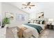 Bright main bedroom with a ceiling fan, large window, neutral carpet, and decoratively staged bed with bench seat at 10651 Streamside Ave, Las Vegas, NV 89129