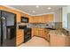 Bright kitchen featuring black appliances, plenty of cabinet space, and attractive granite countertops at 10800 Amber Ridge Dr # 103, Las Vegas, NV 89144