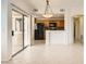 An open layout living room with tile floors that flows into the kitchen and includes sliding glass door access at 10800 Amber Ridge Dr # 103, Las Vegas, NV 89144