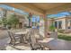 Charming covered outdoor patio features ample seating, BBQ, and views of the well-maintained surrounding landscape at 10800 Amber Ridge Dr # 103, Las Vegas, NV 89144