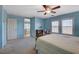 Large bedroom includes a ceiling fan, light-blue walls, and a cozy reading nook by the windows at 112 Austin Rose Ave, Henderson, NV 89002