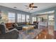 Comfortable living room boasts lots of natural light, hardwood floors, and colorful area rug at 112 Austin Rose Ave, Henderson, NV 89002