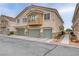 Multi-level home featuring multiple garage doors, landscaped surroundings, and a quaint balcony on the second level at 1150 Red Margin Ct # 101, Las Vegas, NV 89183