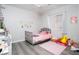 A bedroom with a gray twin bed, princess wall decals, and a pink rug at 1252 Autumn Wind Way, Henderson, NV 89052