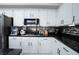 Close-up of a kitchen with white cabinets, granite countertops, and sleek, modern appliances at 1252 Autumn Wind Way, Henderson, NV 89052
