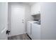 Functional laundry room with white washer and dryer, and overhead cabinet for storage at 1252 Autumn Wind Way, Henderson, NV 89052