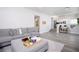 Bright living room featuring a comfortable gray sectional sofa, ottoman, and view into the adjacent kitchen at 1252 Autumn Wind Way, Henderson, NV 89052