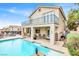 Exterior view of a home featuring a refreshing pool, covered patio, and a second-story balcony at 2020 Rainbow View St, Henderson, NV 89012