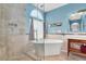 Bright bathroom with tile floors, freestanding tub, and glass-enclosed shower at 2020 Rainbow View St, Henderson, NV 89012