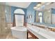 Bright bathroom with tile floors, glass shower, and a freestanding tub at 2020 Rainbow View St, Henderson, NV 89012
