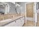 Bathroom with double sinks, granite countertops, and tiled shower, offering modern amenities and style at 2020 Rainbow View St, Henderson, NV 89012