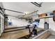 Spacious garage with a Peloton bike, storage shelves, and room for a workout area at 2020 Rainbow View St, Henderson, NV 89012