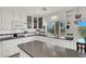 Well-lit kitchen boasts white cabinetry, granite countertops, and a window overlooking the backyard at 2020 Rainbow View St, Henderson, NV 89012