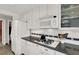 Charming kitchen features white cabinets, stainless steel appliances, and tiled backsplash at 2020 Rainbow View St, Henderson, NV 89012