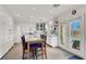 Bright kitchen with white cabinets, stainless steel appliances, dining area, and door to the backyard at 2020 Rainbow View St, Henderson, NV 89012