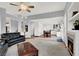 Spacious living room with ceiling fan, fireplace, open floor plan, and views of the kitchen and staircase at 2020 Rainbow View St, Henderson, NV 89012