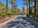 Scenic street view lined with tall palm trees and colorful flower beds, leading to an elegant building at 2020 Rainbow View St, Henderson, NV 89012
