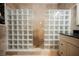 A walk-in shower features glass block and travertine tile at 2050 W Warm Springs Rd # 4322, Henderson, NV 89014