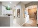 Open hallway features neutral paint, art, and tile flooring leading to kitchen and stairs at 2050 W Warm Springs Rd # 4322, Henderson, NV 89014