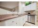 Bright kitchen features white cabinets, stainless steel appliances, and granite countertops at 2050 W Warm Springs Rd # 4322, Henderson, NV 89014