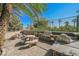 Outdoor kitchen featuring a built-in BBQ grill, picnic tables, and mature landscaping for a relaxing dining experience at 2050 W Warm Springs Rd # 4322, Henderson, NV 89014
