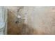 Close up of travertine tiled shower walls with a showerhead and small corner shelf at 2050 W Warm Springs Rd # 4322, Henderson, NV 89014