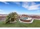 A round swimming pool with an artificial rock waterfall feature and artificial turf at 2491 Hardin Ridge Dr, Henderson, NV 89052