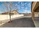 Spacious backyard with gravel landscaping, a white fence, and a covered patio, perfect for outdoor living at 2648 E Sparrow Way, Pahrump, NV 89048