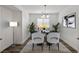 Bright dining room featuring modern chandelier, four chairs, wood flooring and art at 2648 E Sparrow Way, Pahrump, NV 89048