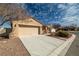 Well-maintained home with a spacious driveway leading to a garage and a landscaped front yard at 2648 E Sparrow Way, Pahrump, NV 89048