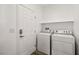 Clean laundry room with white appliances, shelf storage, and a conveniently placed door at 2648 E Sparrow Way, Pahrump, NV 89048
